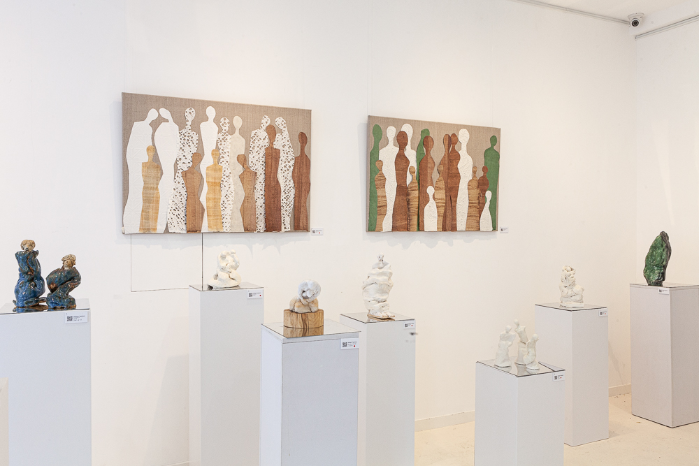 Gallery view showing collages on the wall and ceramic works on plinths