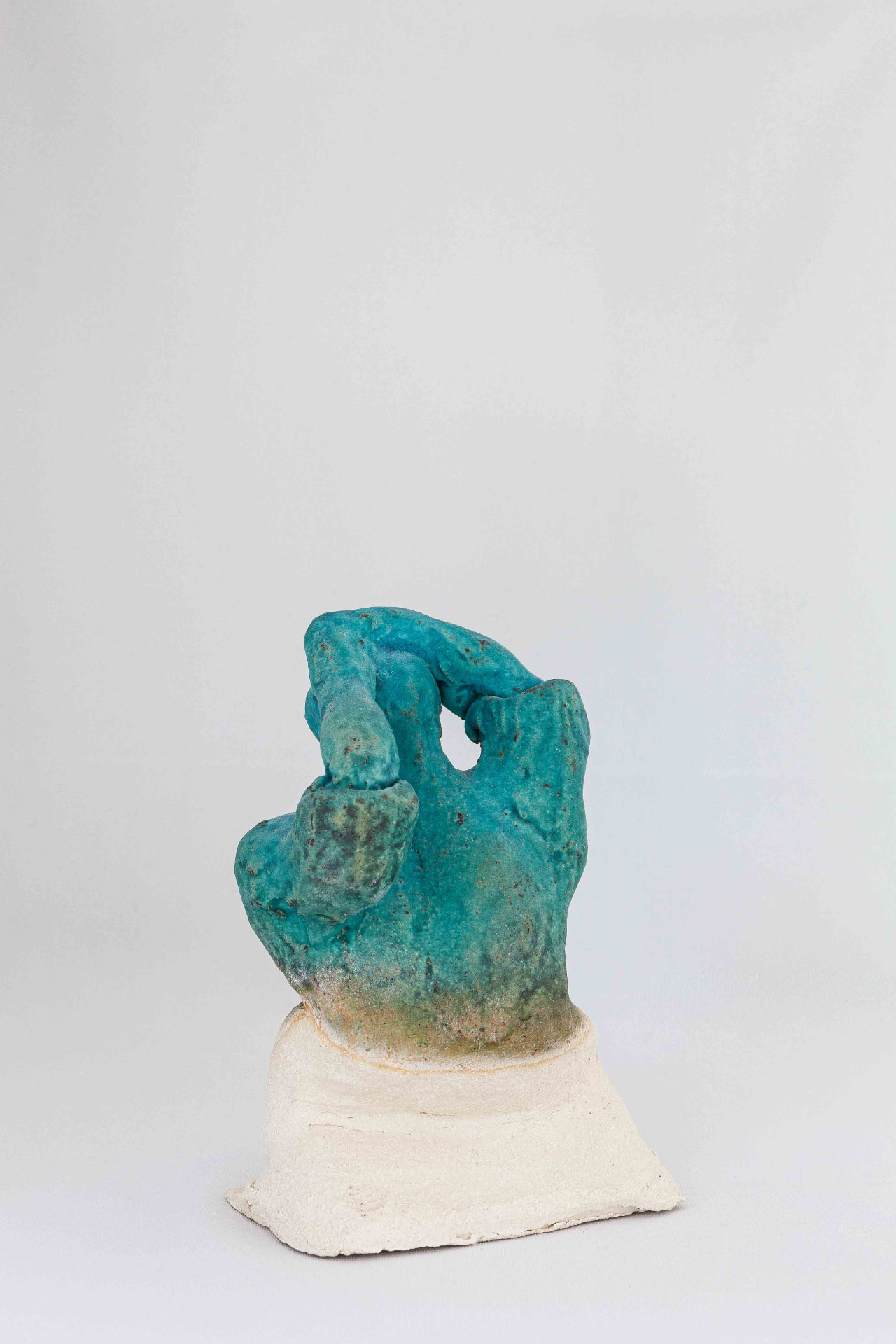 Turquoise glazed ceramic form on a pale stoneware base